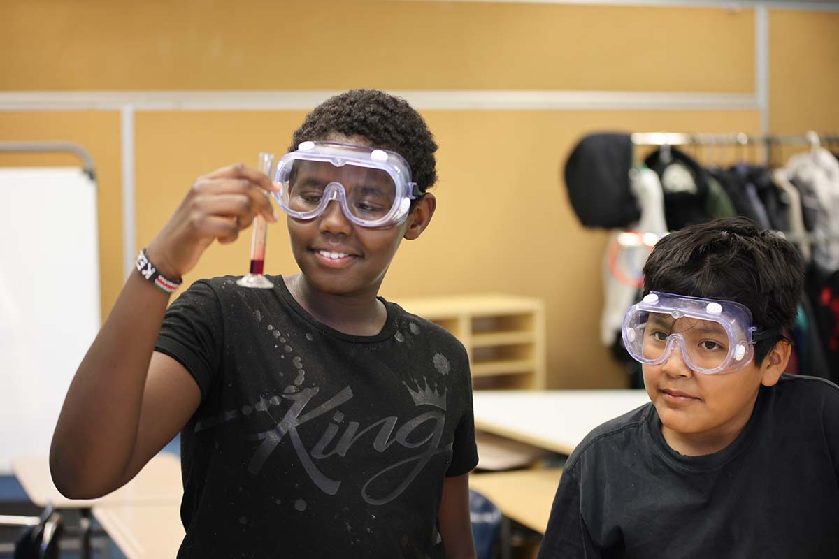 Elementary student smiling and posing together in a classroom.