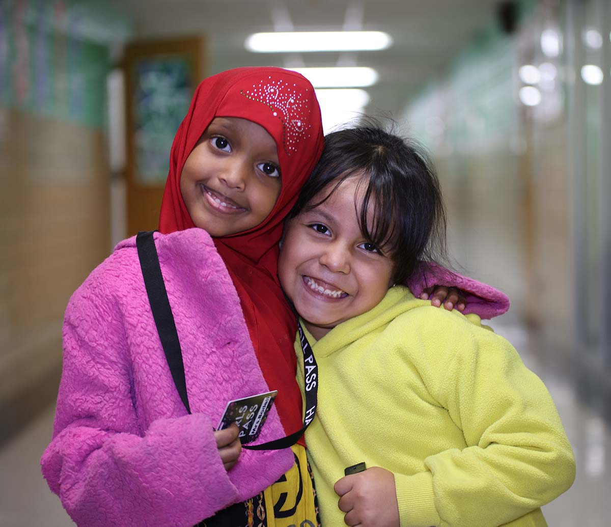 Teacher or school staff member warmly interacting with a student outside